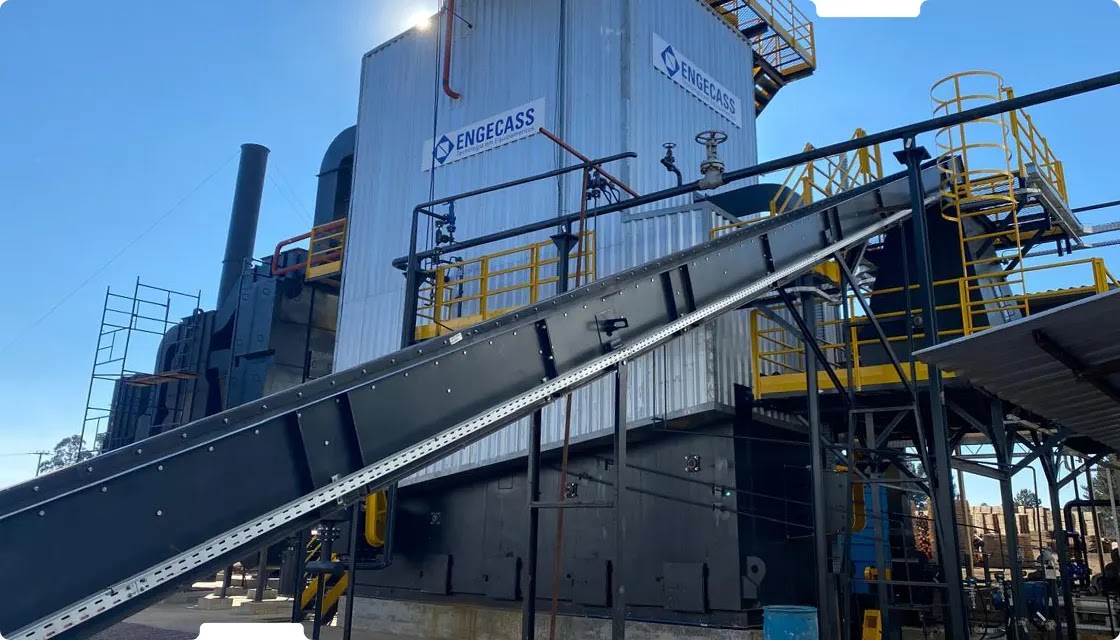 Equipamento industrial da Engecass em uma planta, com esteira transportadora e estruturas metálicas. Equipamento industrial da Engecass em uma planta, com esteira transportadora e estruturas metálicas.